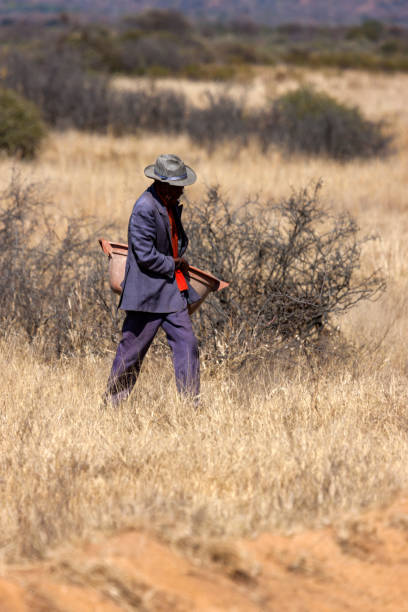 portrait african old man carry bucket on a dirt road in the village bush