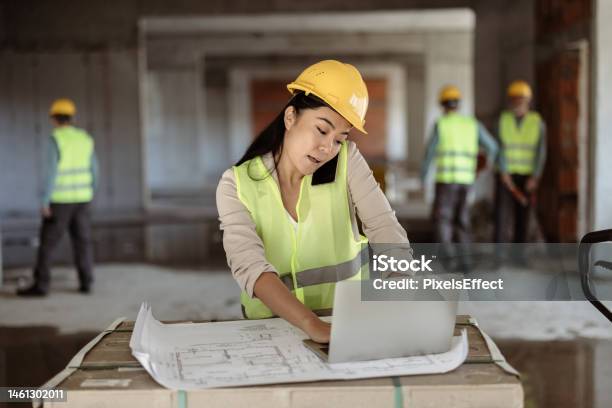 Female Architect Talking On The Mobile Phone At Construction Site Stock Photo - Download Image Now