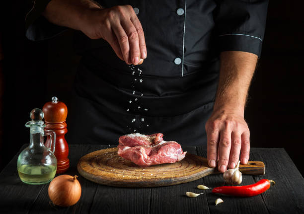 istock The chef sprinkles the meat with salt. Preparing meat before baking. Working environment in restaurant kitchen. 1461302210