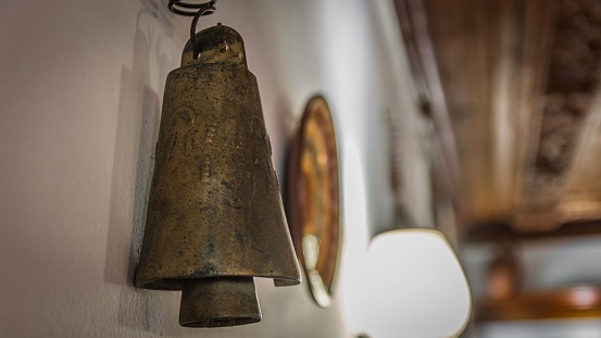 an Old handmade bell on the wall.