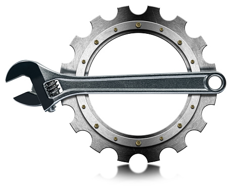 Closeup of a modern stainless steel adjustable wrench on a metal gear (cogwheel), isolated on white background with copy space and reflection.