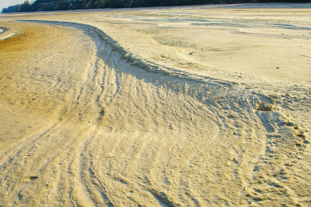 Natural background texture of frozen sand. Winter beach view