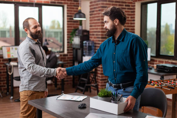 istock Businessman greeting sad fired entrepreneur man while carrying his box 1461311154