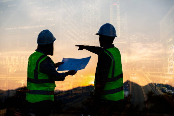istock Double exposure image of engineer civil and construction worker with safety helmet and construction drawing against the background of surreal construction site in the night city or dark cityscape. 1461313527