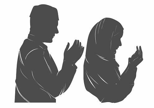 silhouettes of men and women in hijab praying.
