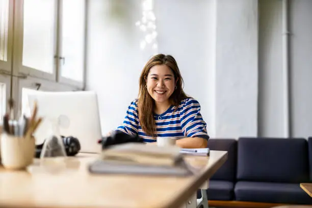 Young woman sitting at desk working on laptop