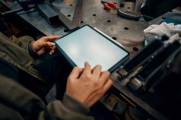 istock Mid adult female using a digital tablet in a metal fabrication workshop 1461316916