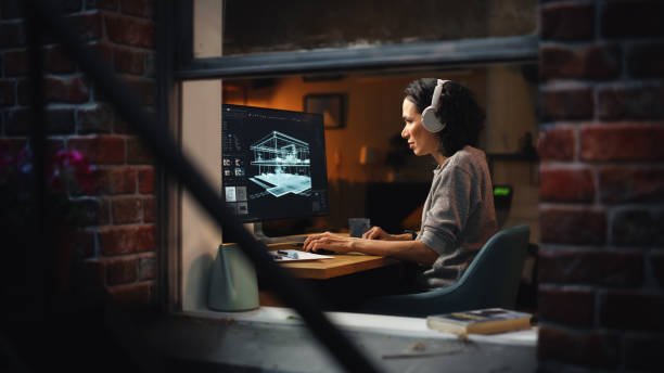 istock Creative Female 3D Architect Artist Using Desktop Computer with Screen Showing CAD Real Estate Project. Brazilian Woman Video Game Developer Creating Gaming Level. View Into the Apartment Window. 1461319466