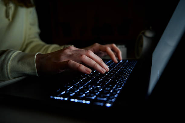 istock Anonymous woman working on laptop at night 1461319491
