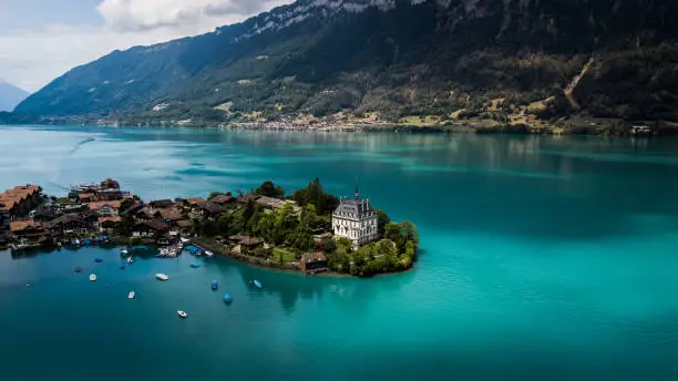 it's a drone shot in switzerland of an house in the center of a lake interlaken