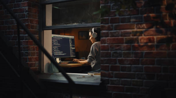 istock Latin Female Digital Startup Entrepreneur Working on Computer Late at Night. Software Developer Working on Innovative e-Commerce App. Overworking Concept. Shot Into the Window From Outside. 1461321352