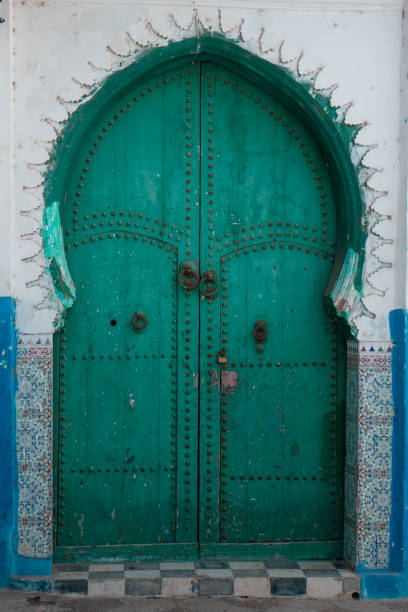 istock Old green door on a blue and white moroccan facade 1461322999