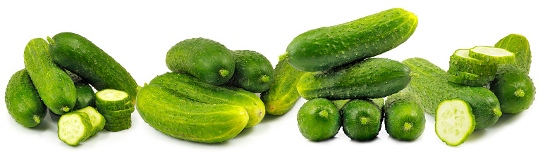 Image of fresh green cucumbers lying in a row on a white background close-up
