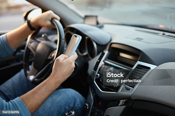 Hands Of Unrecognizable Man Driver Using Mobile Phone While Driving Stock Photo - Download Image Now