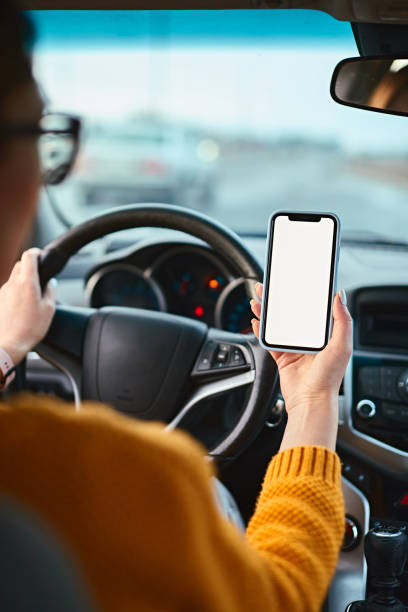 maqueta de pantalla en blanco del teléfono móvil en manos de una conductora en un automóvil - driving text messaging accident car fotografías e imágenes de stock