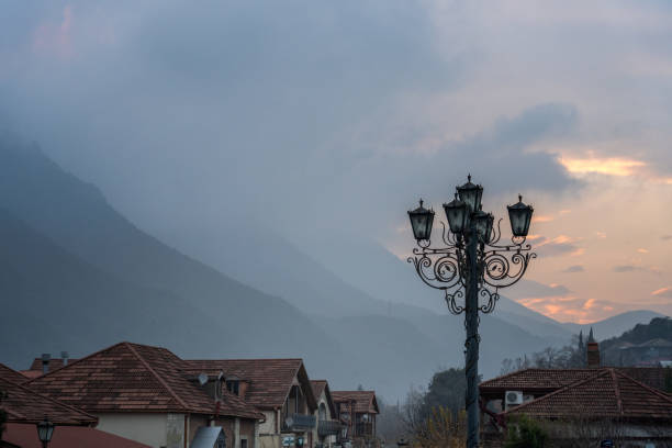 Red rooftops and lantern with mountains on background at sunset in Mtskheta. Georgia
