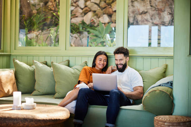 istock Smiling young couple watching something on a laptop on their sofa 1461334632
