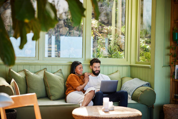 istock Smiling young couple watching something on a laptop at home 1461335276