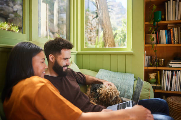 istock Couple watching something on a laptop while sitting at home with their dog 1461337106