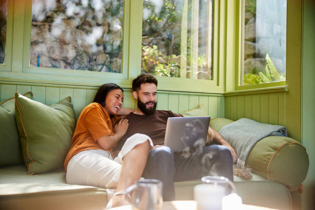 istock Couple laughing at something on a laptop while sitting at home with their dog 1461337401