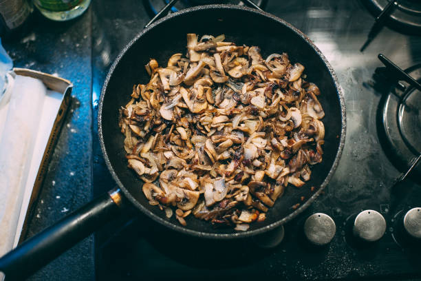 Cooking mushrooms in a pan. Stirring with a spatula.