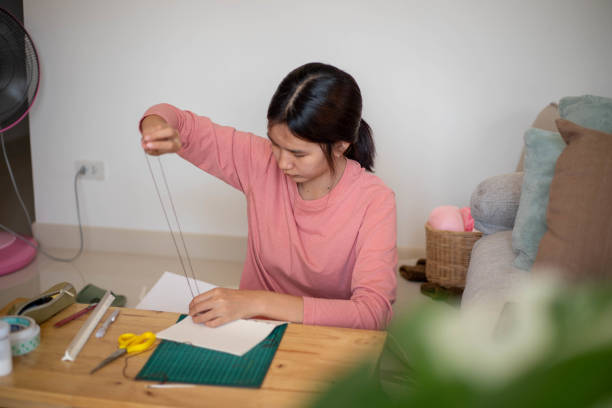istock An inventive young woman sewing her own notebook. 1461339648