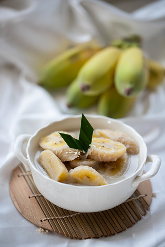 Banana slices in bowl over stone background with copy space. Healthy natural vitamin snack. Top view, flat lay