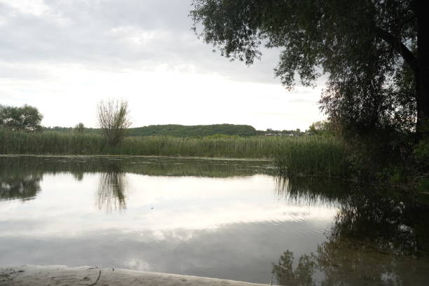 cumulo nimbus clouds at sunset reflected in a lake