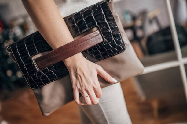 Unrecognizable elegant woman holding modern leather purse.