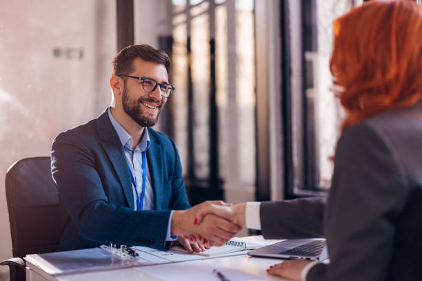 istock Happy bank manager shaking hands with a client after successful agreement in the office. 1461343647