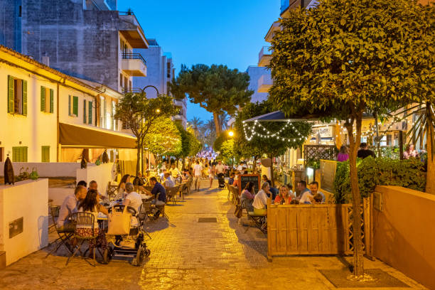 Alcudia night life, Majorca, Balearic Islands, Spain Wide angle view of a busy street with people eating out at restaurants, Alcudia, Majorca, Balearic Islands, Spain bay of alcudia stock pictures, royalty-free photos & images