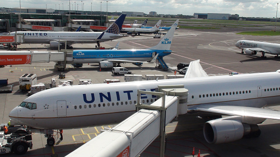 Iceland Air Plane Wing  with KLM Boeing in background, Schipol Airport, Amsterdam, Netherlands - 22 June 2022 : The Iceland Air plane wing can be seen against the backdrop of a KLM Boeing plane ready for take off at Schipol Airport, the main International airport in The Netherlands