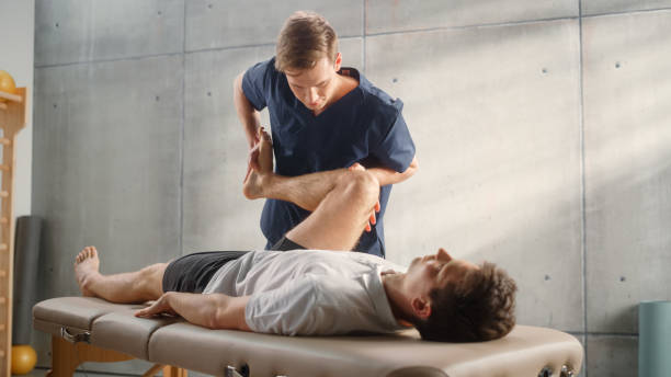 istock Advanced Sport Physiotherapy Specialist Stretching and Working on Muscle Groups or Joints with Young Male Athlete. Fit Sportsman Recovering from Mild Injury, Undergoing Rehabilitation. 1461351837