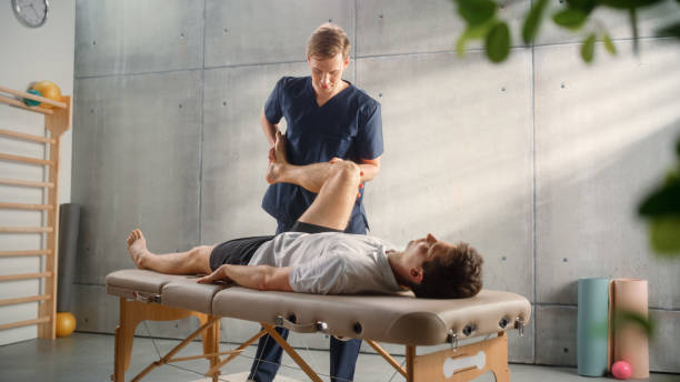 istock Advanced Sport Physiotherapy Specialist Stretching and Working on Specific Muscle Groups or Joints with Young Male Athlete. Fit Sportsman Recovering from Mild Injury, Undergoing Rehabilitation. 1461351961