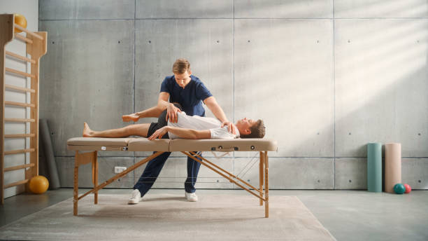 istock Advanced Sport Physiotherapy Specialist Stretching and Working on Specific Muscle Groups or Joints with Young Male Athlete. Sportsman Recovering from Injury, Undergoing Rehabilitation. 1461352016