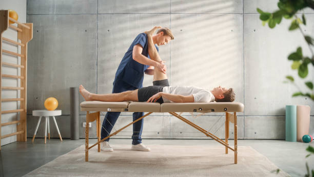 istock Advanced Sport Physiotherapy Specialist Stretching and Working on Specific Muscle Groups or Joints with Young Male Athlete. Sportsman Recovering from Mild Injury, Undergoing Rehabilitation. 1461352038