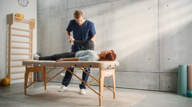 istock Advanced Sport Physiotherapy Specialist Stretching and Working with Specific Muscles Groups or Joints with Elderly Woman. MIddle Aged Female Recovering from Mild Injury, Rehabilitation in Clinic. 1461352071