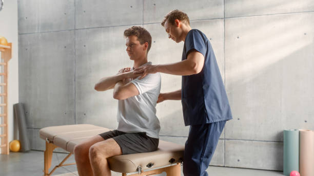 istock Professional Sport Physiotherapist Working on Specific Muscle Groups and Curing Back Pain with Young Male Athlete. Sportsman Recovering from Mild Injury. Trauma Prevention Therapy and Rehabilitation. 1461352604
