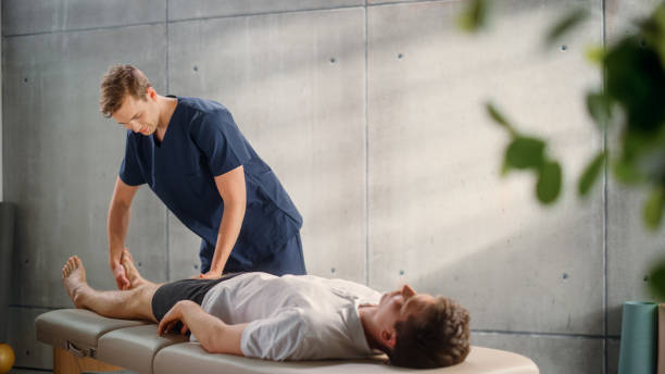 istock Professional Sport Physiotherapist Working on Specific Muscle Groups or Joints with Young Male Athlete. Fit Sportsman Recovering from Mild Injury. Trauma Prevention Therapy or Rehabilitation. 1461352772