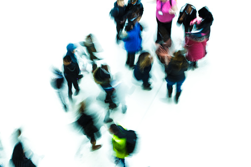 Abstract image depicting a high angle view of blurred motion of people walking around in the city. The long exposure used has created an abstract, impressionist effect.