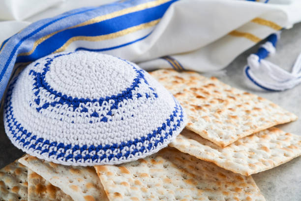 concepto de celebración de la pascua. matzá, kosher rojo y nuez. ritual tradicional judío de pan matzá, kipá y talit sobre un antiguo fondo de hormigón. comida de pascua. fiesta judía de pésaj. - passover seder matzo judaism fotografías e imágenes de stock