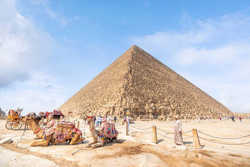 Pyramids of Giza, Giza Necropolis, Egypt - July 26, 2022: The Giza Necropolis is a large area near Giza, a suburb of Cairo that has many tombs and burial sites. It is also where you can find the famous Pyramids of Giza, the Great Sphinx, and more. The name comes from the ancient Greek word nekropolis, which literally means “city of the dead”.\n\nThe Giza Complex was once near the ancient Egyptian capital of Memphis, and the Giza plateau is where a number of pharaohs, queens, and nobles of the Fourth Dynasty of ancient Egypt were buried. \n\nAll three of Giza's pyramids and their elaborate burial complexes were built  from roughly 2550 to 2490 B.C. The pyramids were built by Pharaohs Khufu, Khafre, and Menkaure.