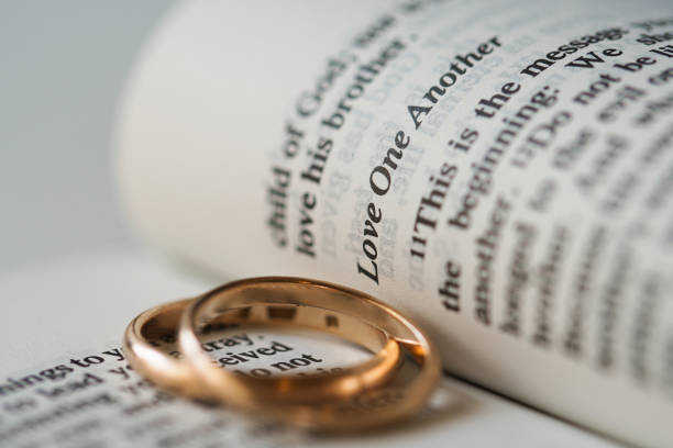 2つの金色の結婚指輪と聖書の開いたページは、結婚の概念と2人のクリスチャン間の愛を表しています