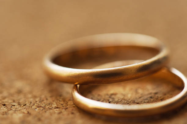 Macro of two wedding rings on a cork table background with shallow DOF