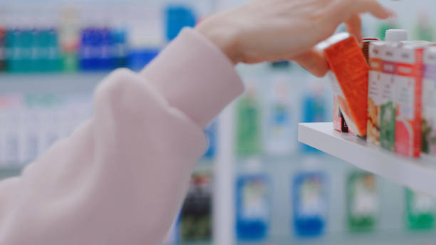 Woman takes product from a shelf in store stock photo