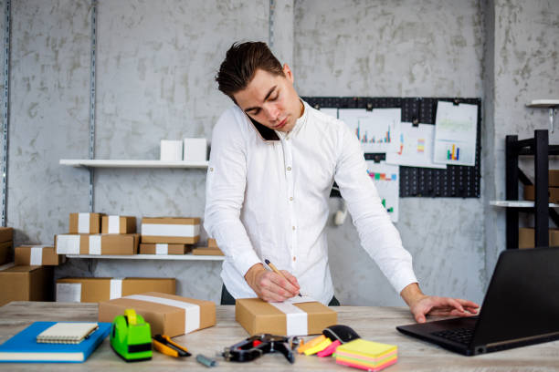 istock Young man labeling packed products for customers 1461362560