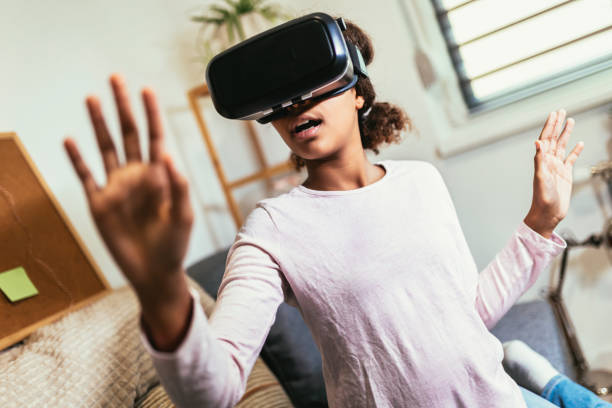 istock African American girl using virtual reality glasses in her room. 1461365390