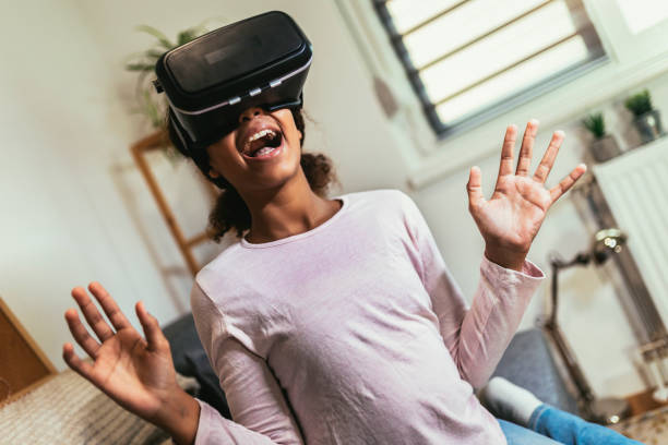 istock African American girl using virtual reality glasses in her room. 1461365678