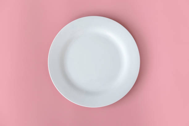 istock Top view of empty white plate on a pink background. Flat lay, copy space. 1461365887
