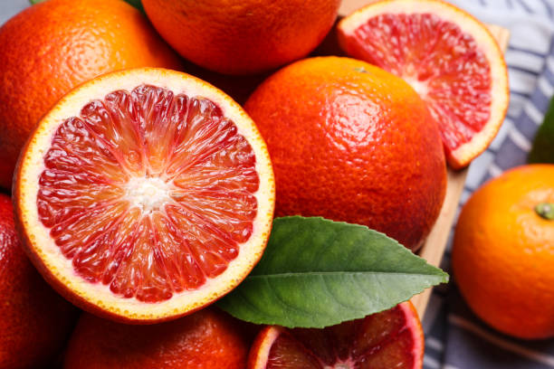 istock Whole and cut ripe red oranges with green leaf, closeup 1461367761